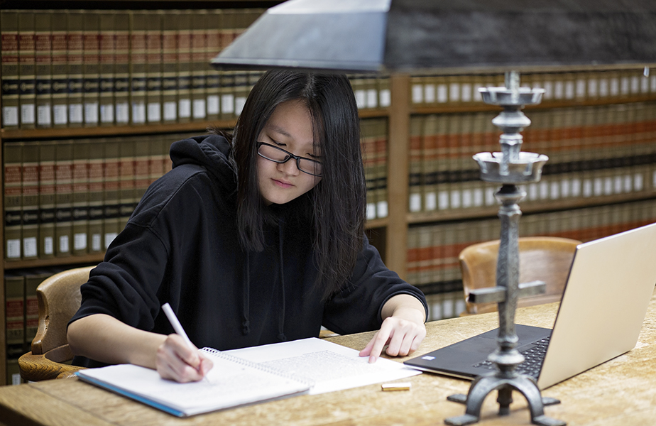 Student working on notes in library